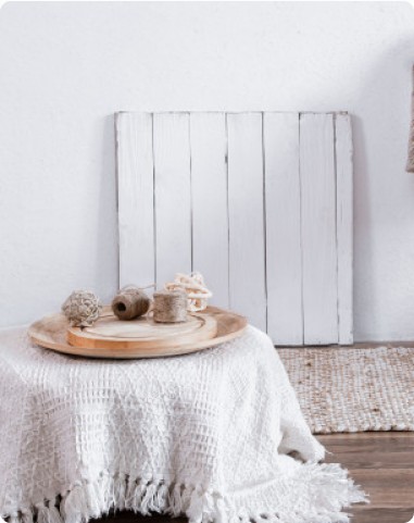 Knitted white table cover with a wooden tray and twine spools