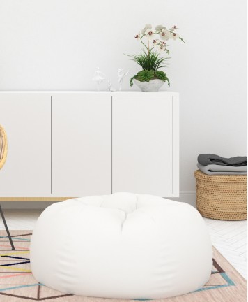 White sideboard with orchid and a white bean bag on a rug